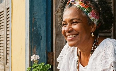 Mulher sorridente com bandana floral em pé na porta de madeira